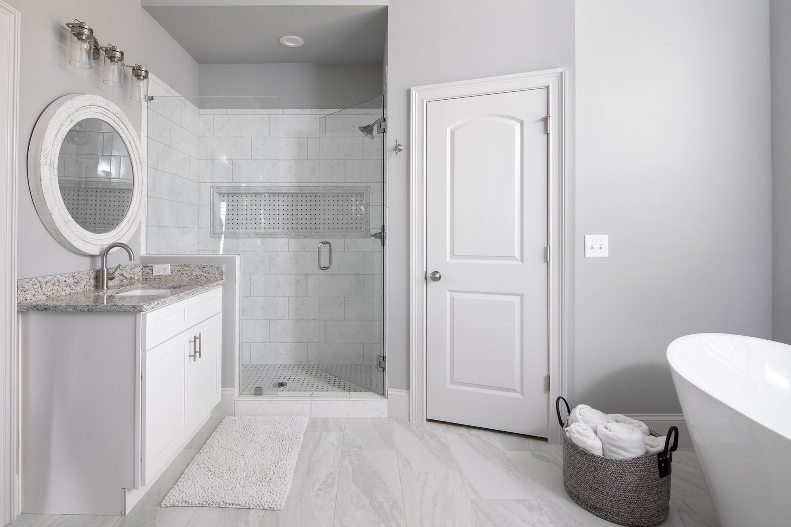Primary bath with tiled walk-in shower and freestanding tub — Imbriale, custom home built by Ironwood Construction Group